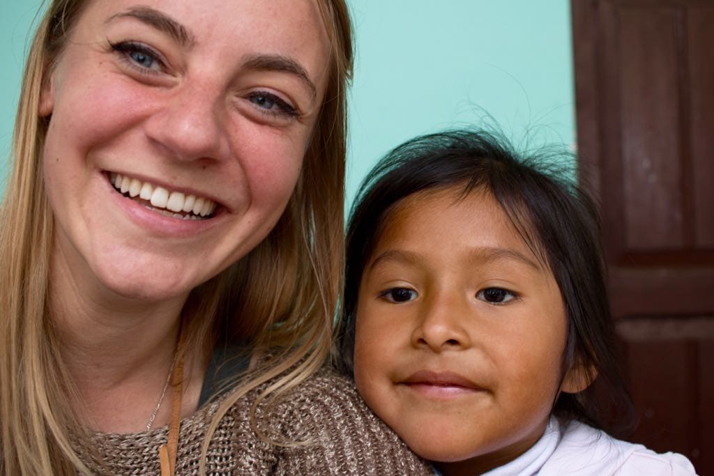 Nicole mit einem kleinen neugierigen Mädchen in Bolivien